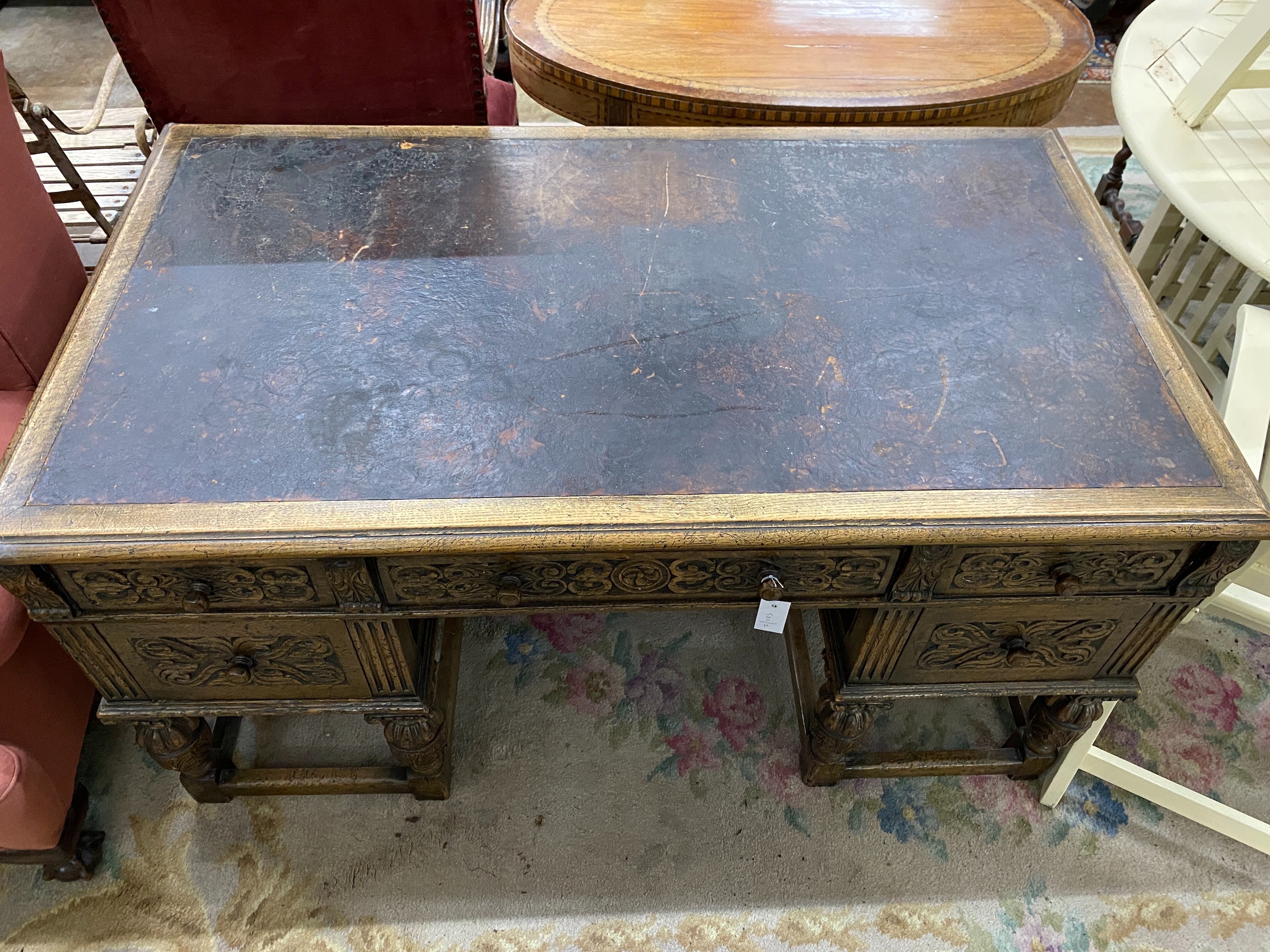 A 1920's Jacobean revival carved oak five drawer kneehole desk, length 144cm, depth 83cm, height 75cm